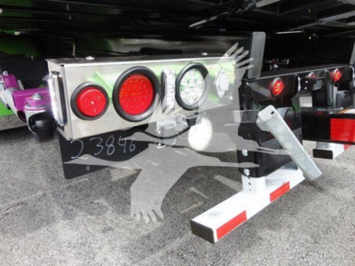 Truck rear showing taillight assembly and under-ride protection with reflective stripes and bumper.
