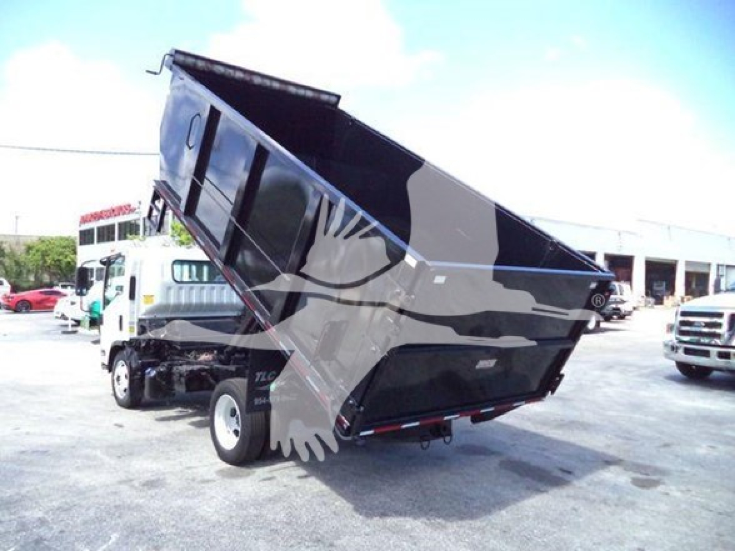 Isuzu NRR dump truck in raised bed position showing cargo bed and rear wheels.