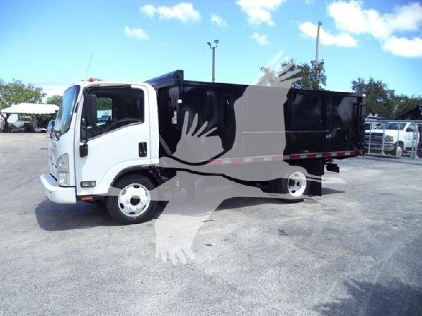Isuzu NPR/NQR dump truck with white cab and black dump bed, side view.