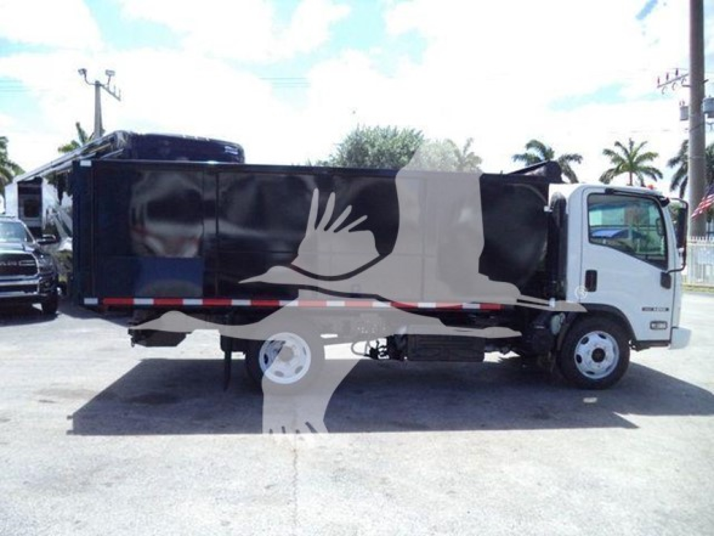 Isuzu NRR dump truck side view with black dump bed and white cab. Visible text includes none clearly readable; stock number and VIN are in context but not on the image.