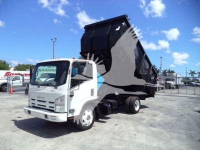 Isuzu NPR/NRR dump truck with hydraulic dump bed raised, white cab, black dump body; appears in a dealership lot.