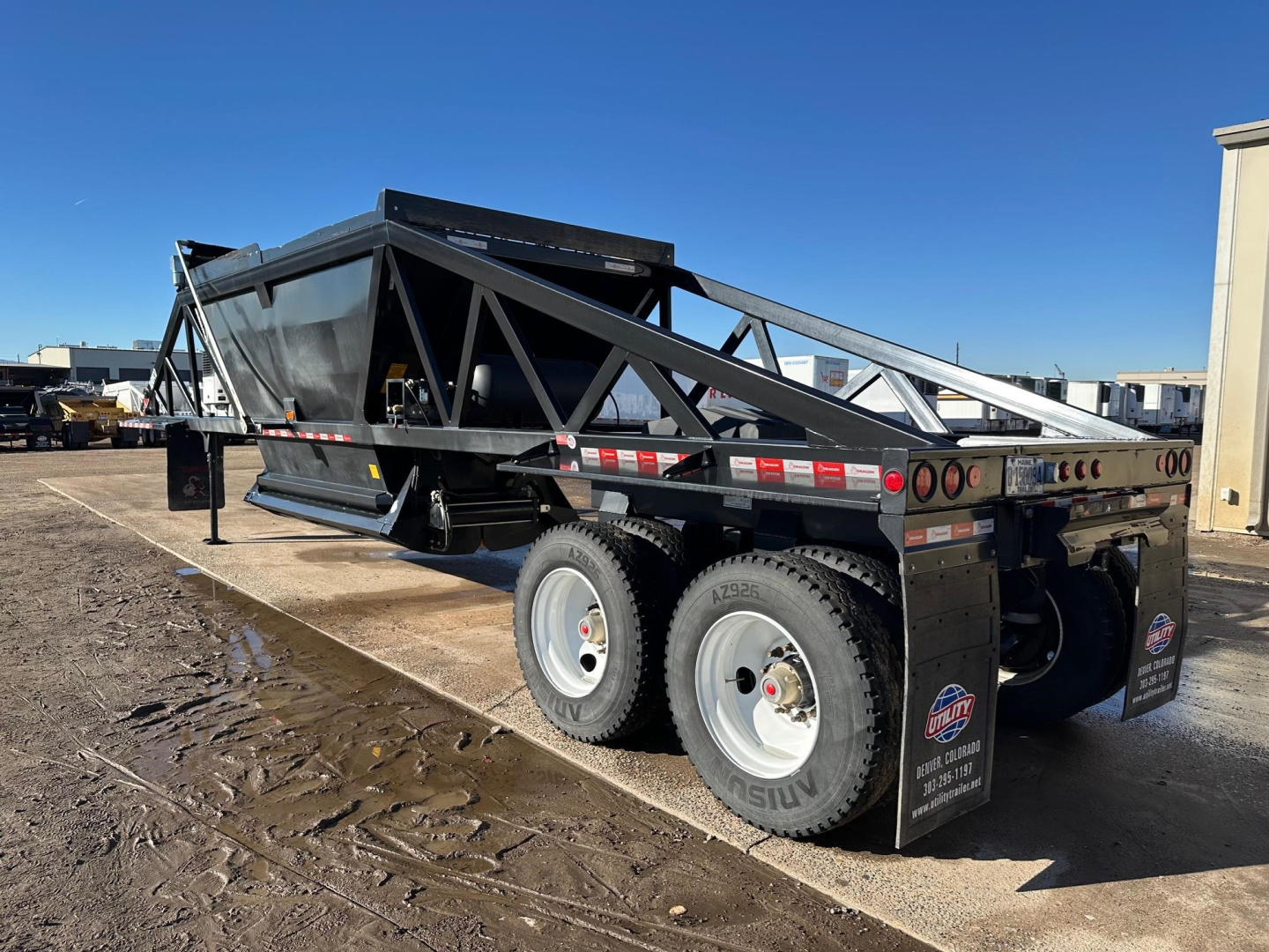 Dump trailer showing LW21-40 model with dual rear axles and black frame. Side rails with reflective tape, tires, and mud flaps visible.