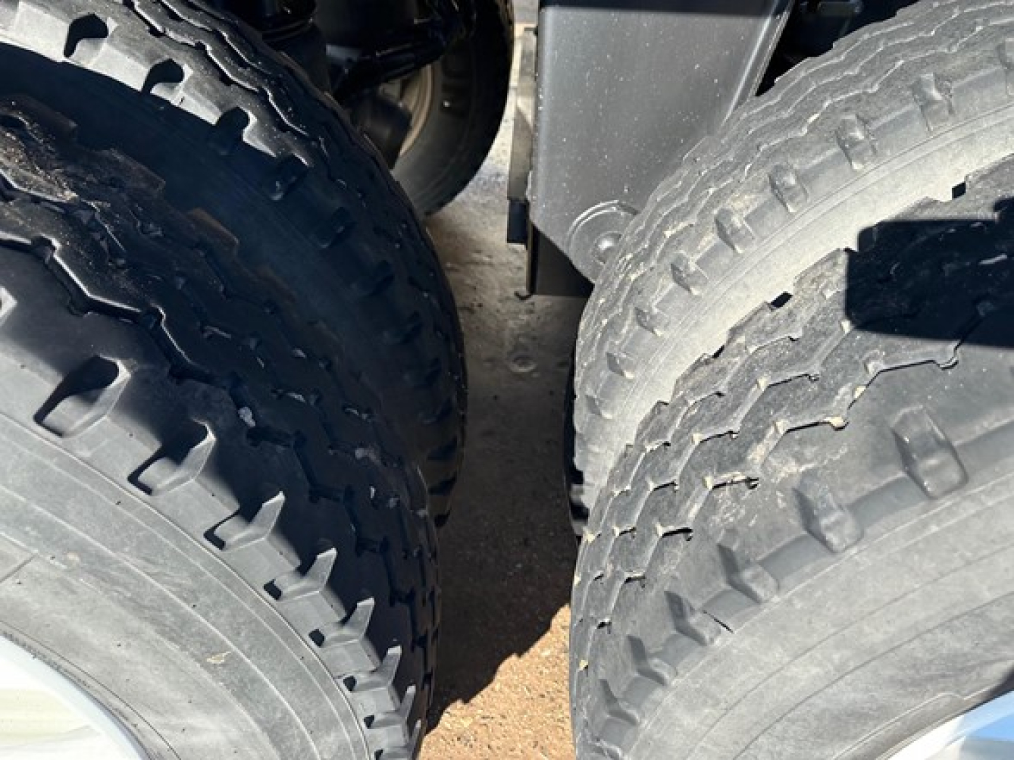 Tandem dump trailer wheels showing heavy-duty tires and suspension components.
