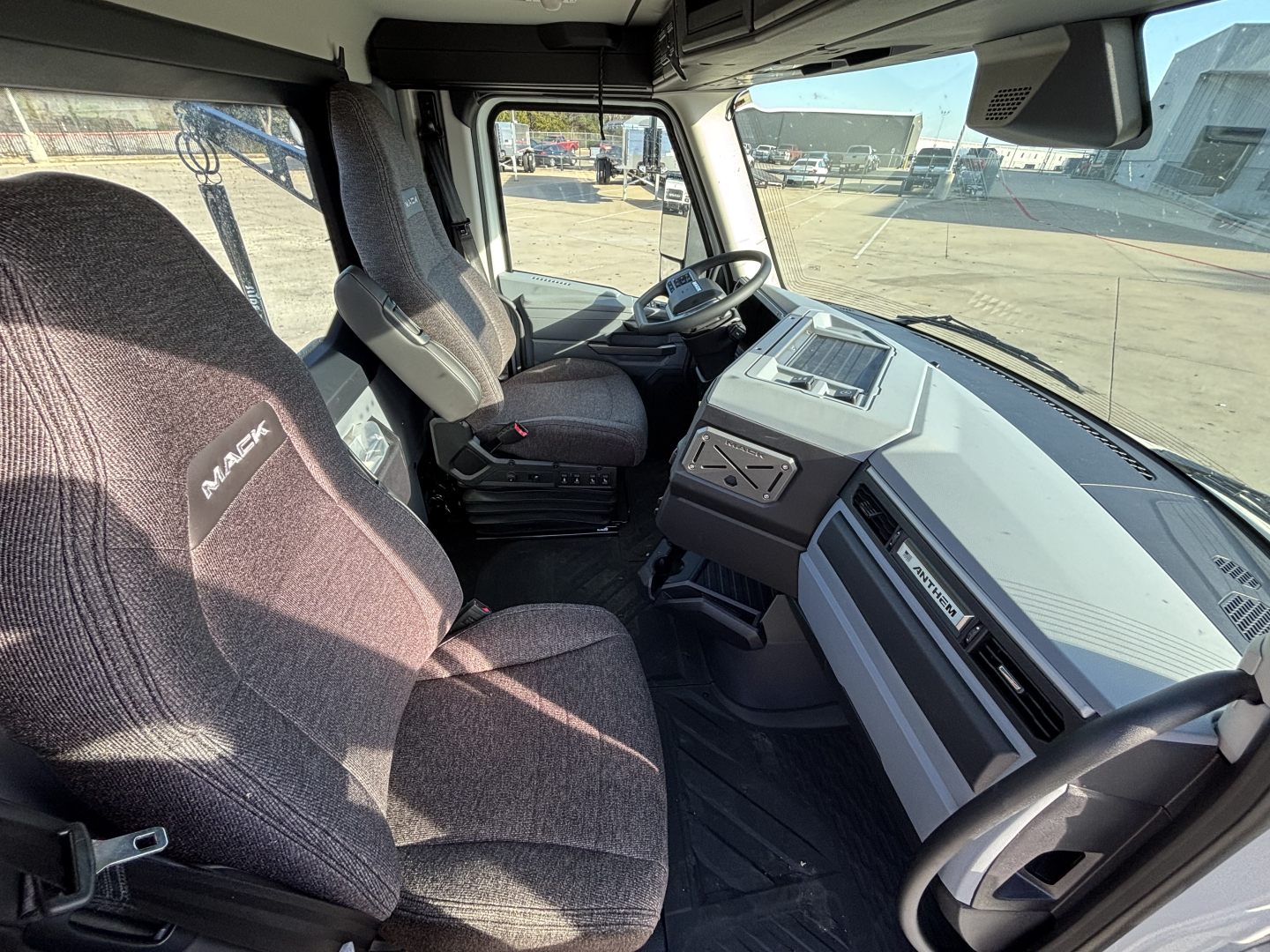 Mack AN64T cab interior showing driver seat and dashboard with steering wheel and control panel.