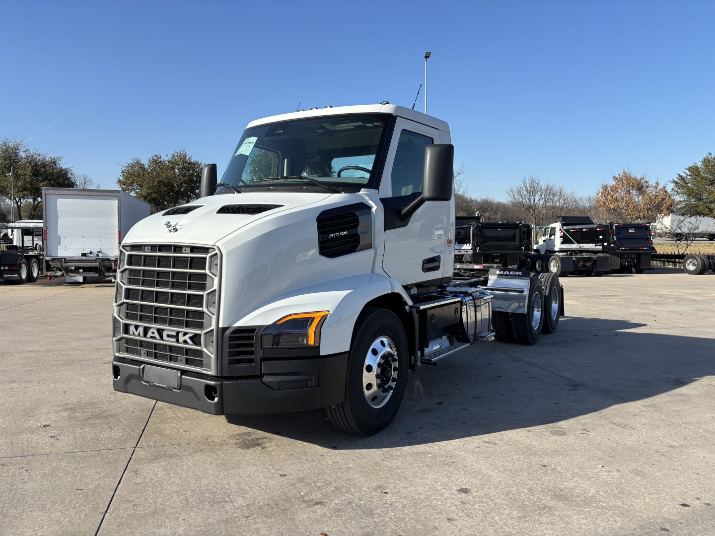 White Mack AN64T truck in a lot, front-left view, with grille, headlights, and 6-wheel configuration visible.
