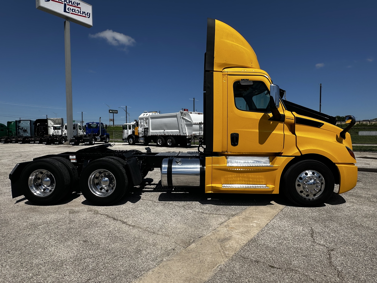 Freightliner Cascadia 126 daycab chassis side view with yellow cab and black frame showing exhaust stack and fuel tanks.