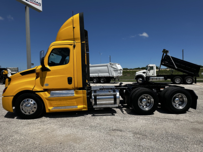 Truck side view showing 2019 Freightliner Cascadia 126 daytime cab with yellow exterior and chassis, long-wheelbase with dual rear axles.