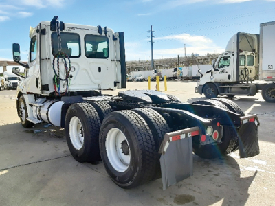 Truck chassis rear view showing six-wheel configuration and 2018 Freightliner Cascadia126 cab in background.