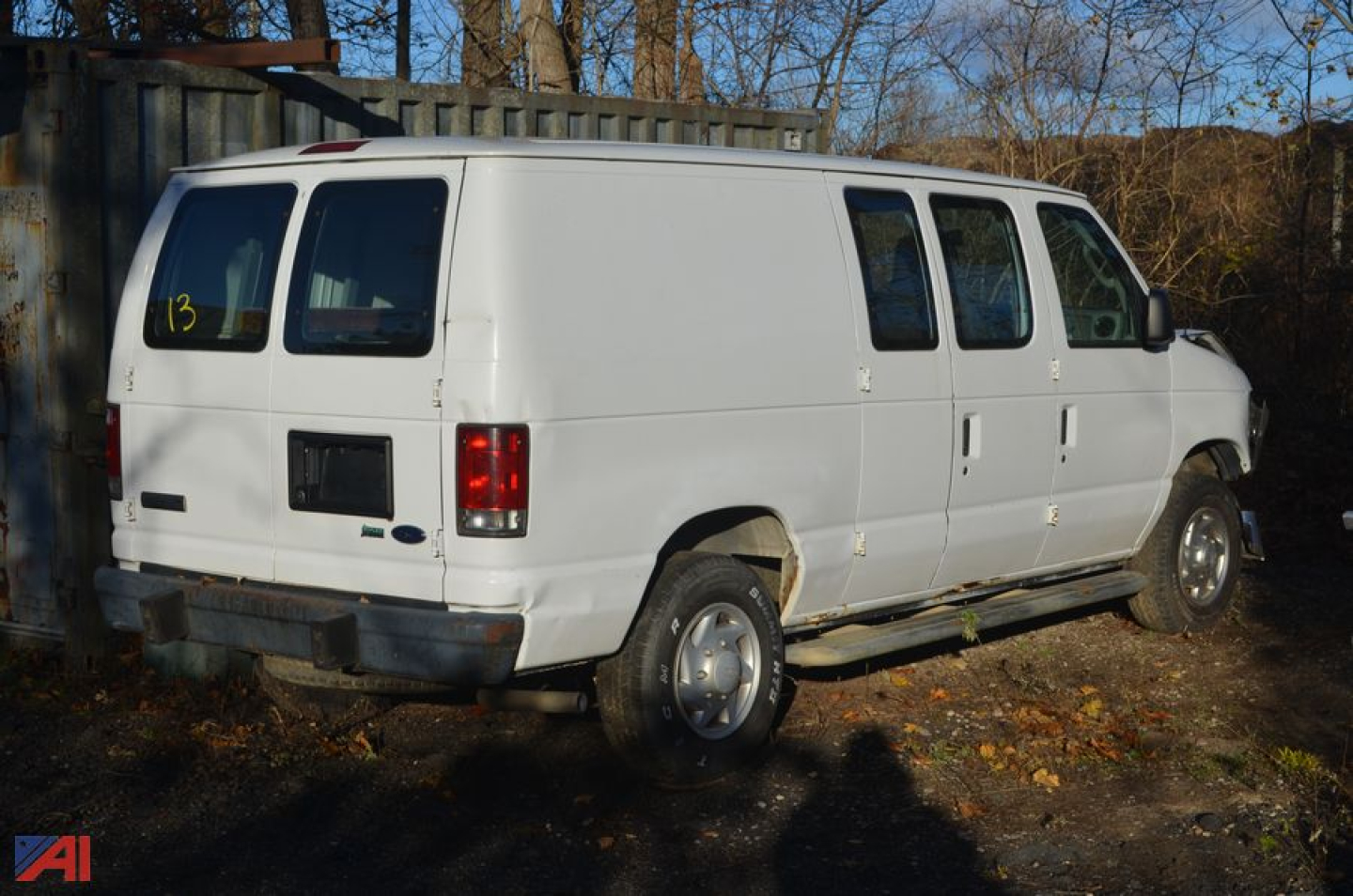 White 2010 Ford E350 cargo van rear and passenger-side view, side windows, standard wheels, used condition.