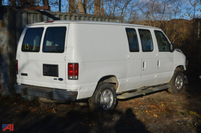 White 2010 Ford E350 cargo van rear and passenger-side view, side windows, standard wheels, used condition.