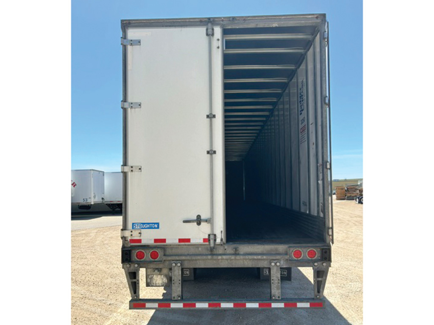 Trailer interior view from rear open doors showing metal framing, ribbed floor, and long cargo space in a used 2019 Stoughton trailer.
