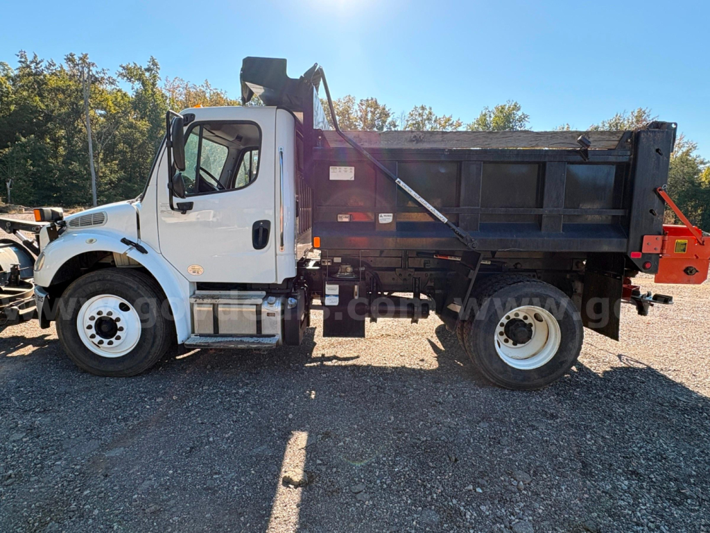 2015 Freightliner M2 dump truck side view showing cab, dump bed, and tires.