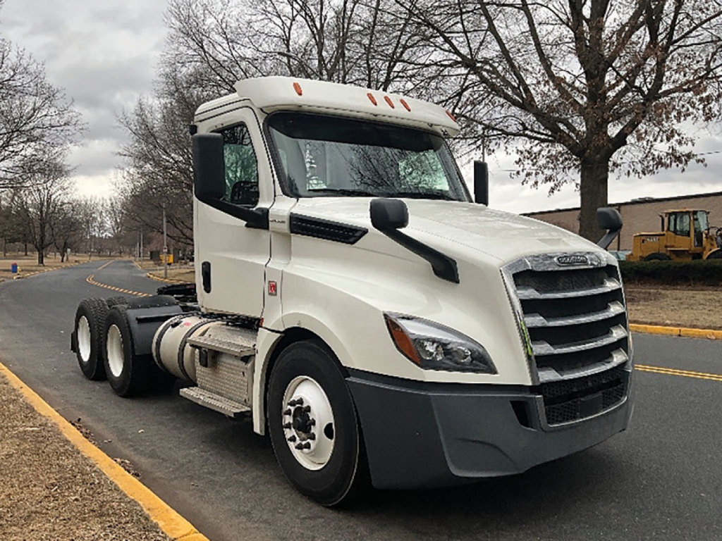 Freightliner Cascadia1220 cab tractor in white, side view showing front grille, headlamps, mirrors, and chassis with dual rear axles.