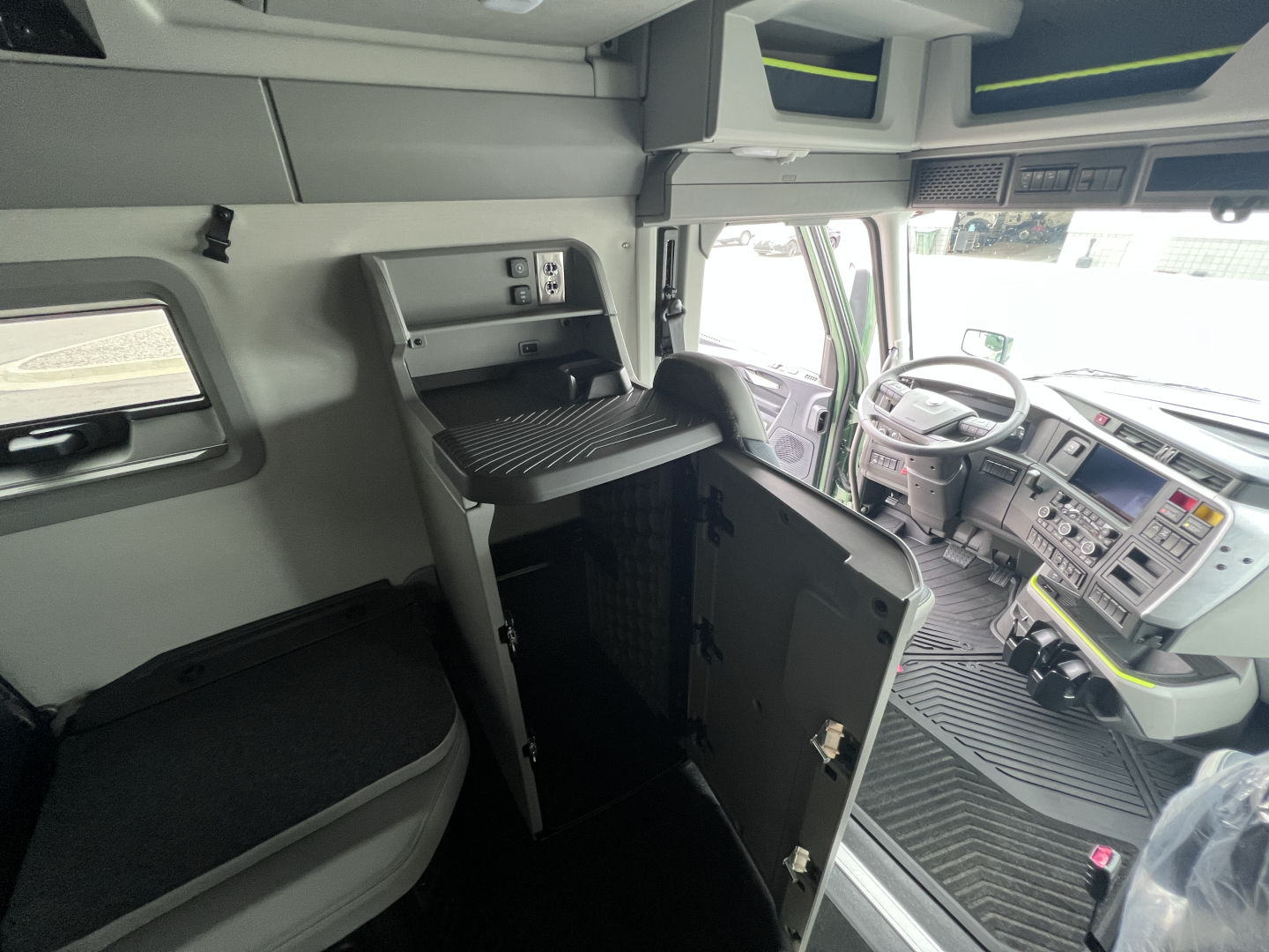 Volvo VNL64T860 truck cab interior showing sleeper bunk cabinet and driver seat with dashboard and steering wheel visible.
