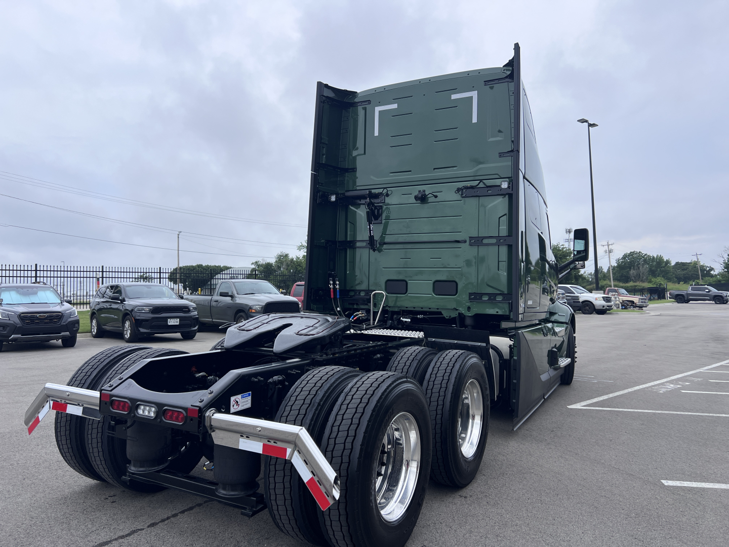 Volvo VNL64T860 tractor rear view showing rear tandem axles and green sleeper cab
