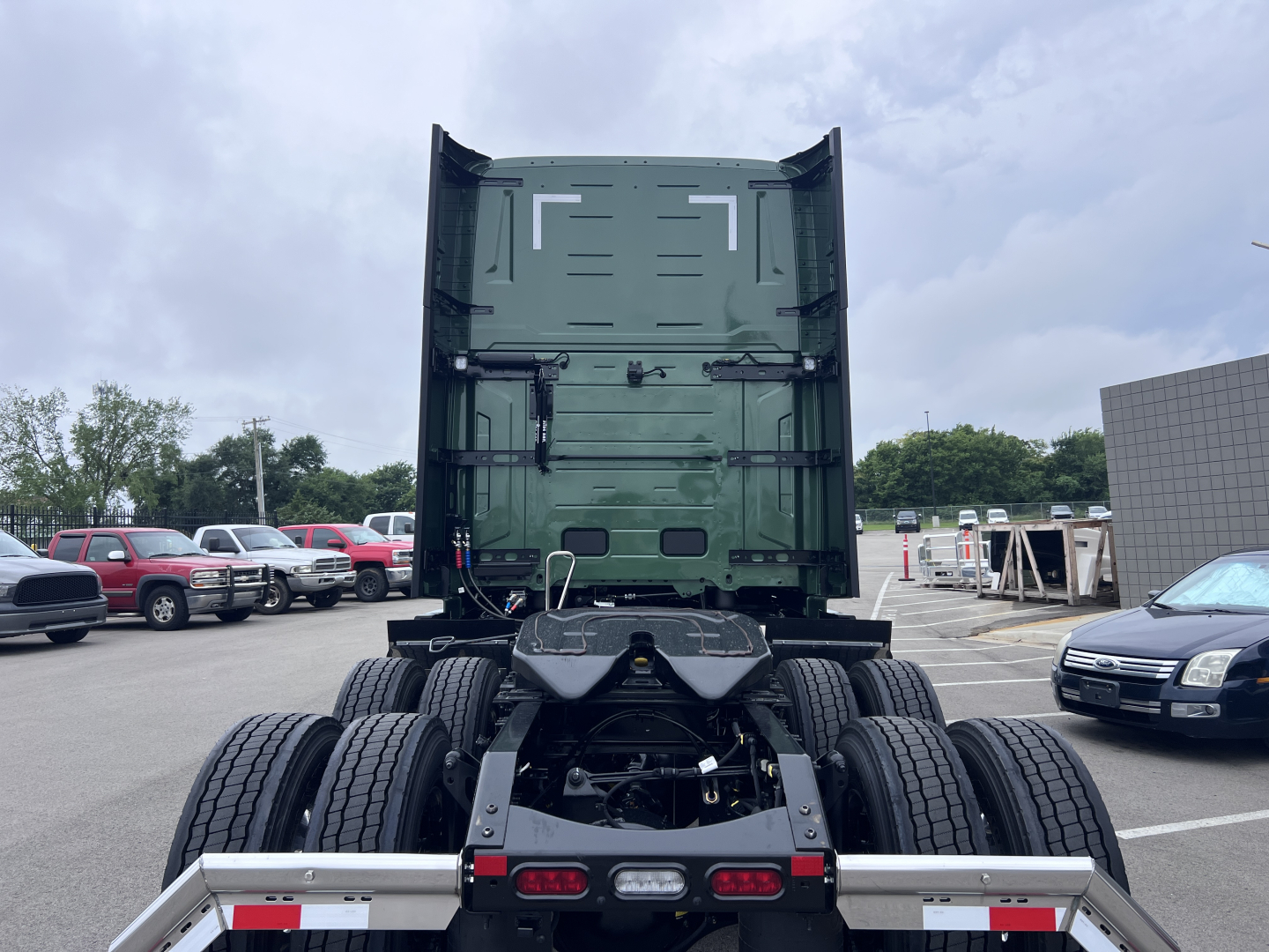Volvo VNL64T860 truck cab and dual rear axles view showing fifth wheel area and chassis in a dealer lot.
