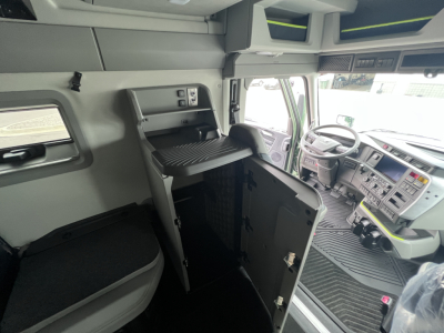 Volvo VNL64T860 truck cab interior showing sleeper bunk cabinet and driver seat with dashboard and steering wheel visible.