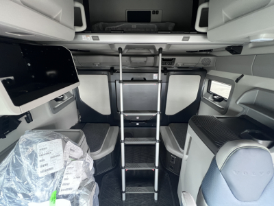 Volvo VNL64T860 cabin interior showing upper bunk ladder, storage compartments, and seating area in a new truck.
