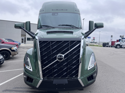 Volvo VNL64T860 truck front view showing large black grille with Volvo emblem and distinctive LED headlights.