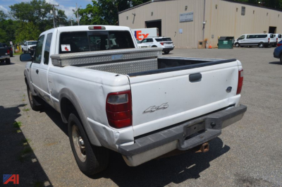 2002 Ford Ranger pickup truck in a used lot, white with a diamond plate toolbox in the bed, 4x4 badge on tailgate, rear bumper, and rear view.