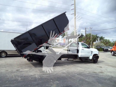 Truck with dump bed raised in a Chevrolet Silverado 6500HD roll-off configuration showing hydraulic lift and dump bed.