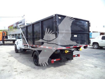 Truck bed showing roll-off dump body mounted on Chevrolet Silverado 6500HD chassis with rear view and license plate area.
