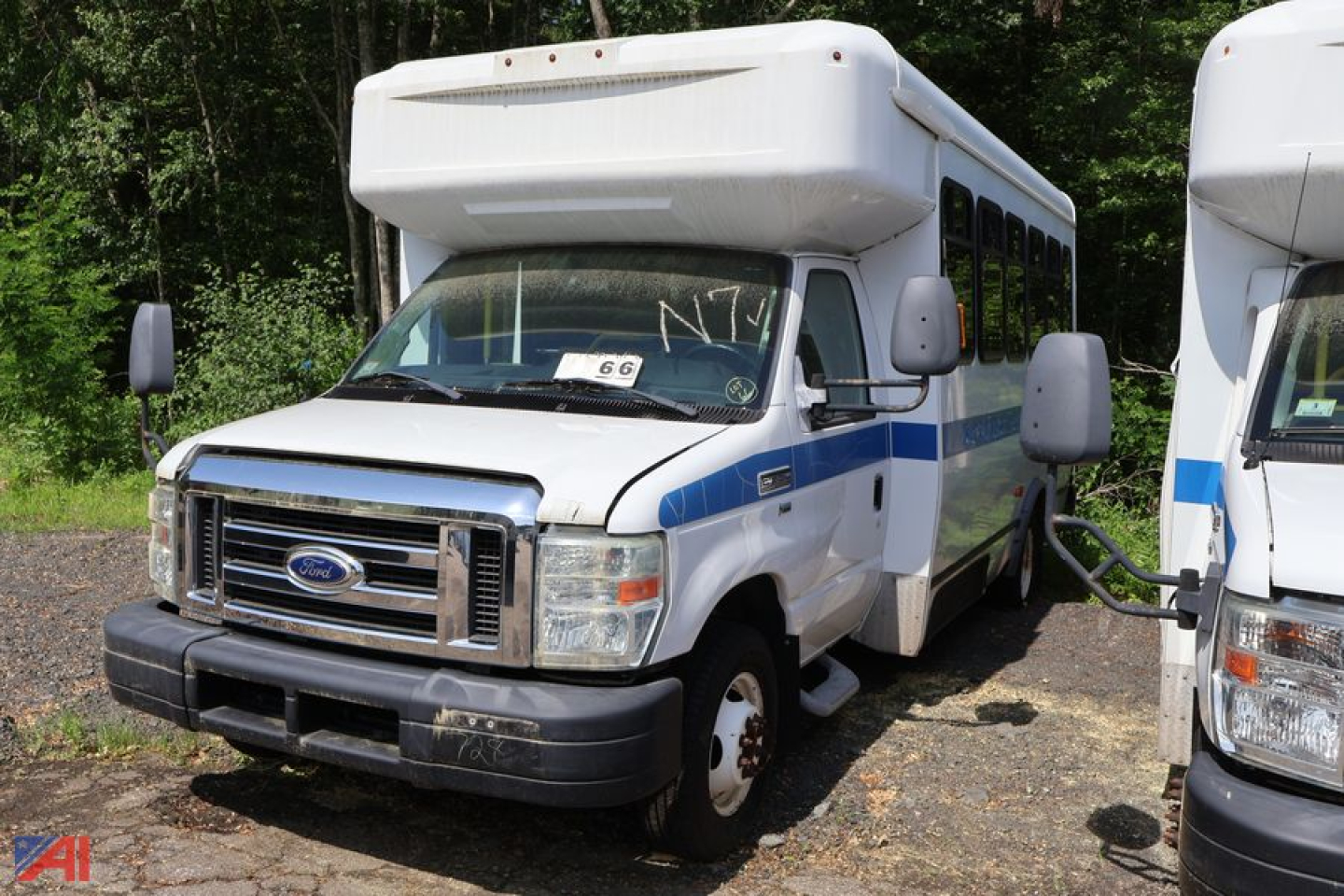 Ford E350 wheelchair bus from front-left view showing cab and side entry with wheelchair bus markings.
