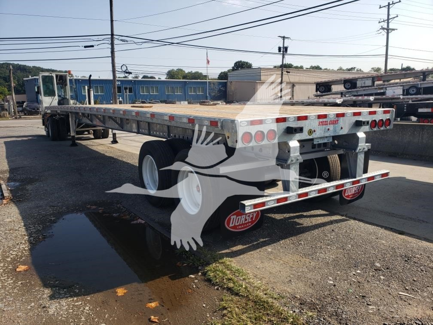 Trailer rear and side view showing flatbed trailer with Dorsey branding mud flaps and taillights.