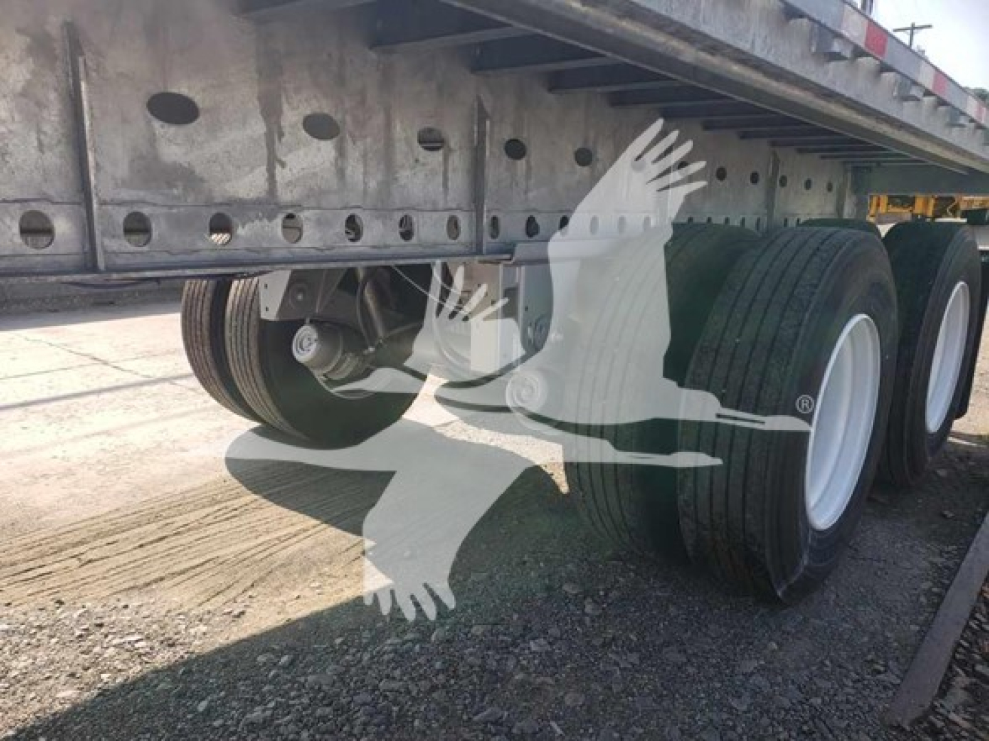 Galvanized flatbed trailer undercarriage showing dual rear axles, wheels, and underframe with Dorsey branding watermark.