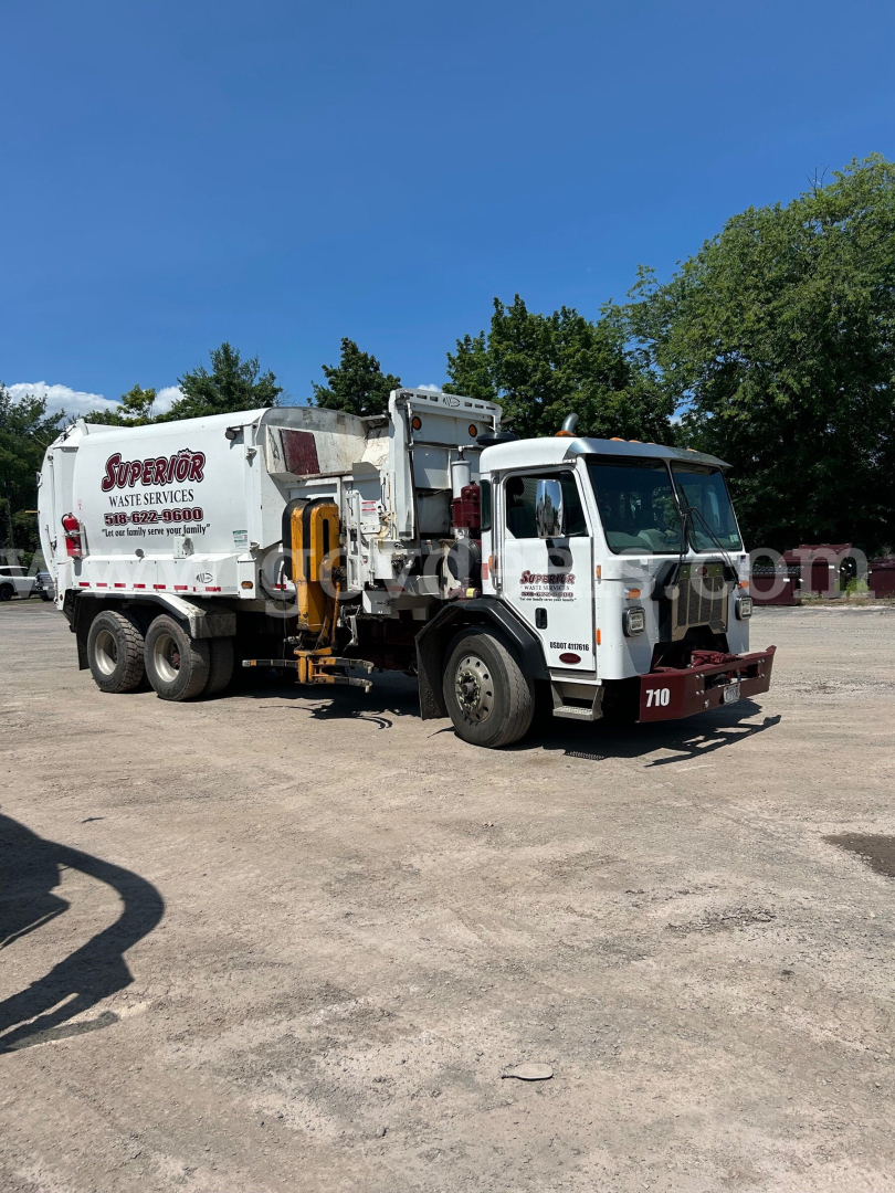 Peterbilt 350 garbage truck in-service showing waste collection body and cab with truck number 710.