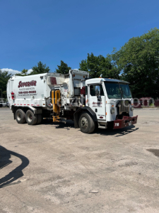 Peterbilt 350 garbage truck in-service showing waste collection body and cab with truck number 710.