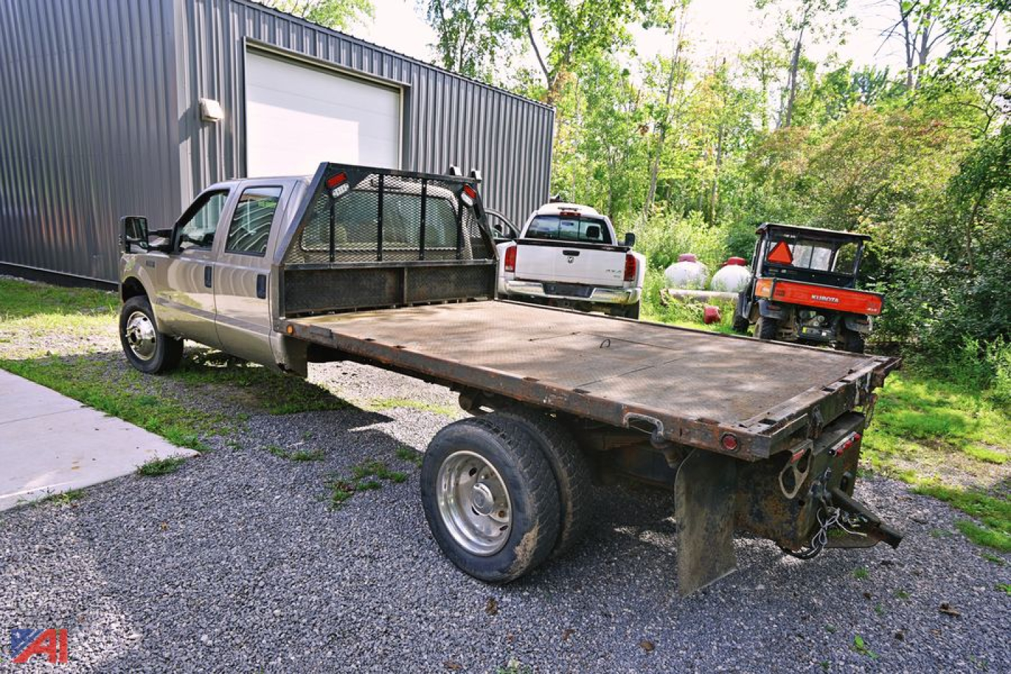 Ford F-550 stake bed truck in a yard with flatbed and dual rear wheels, VIN visible from listing context