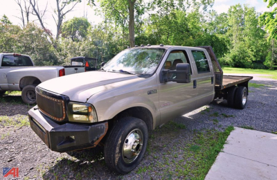 Ford F-550 stake bed truck shown in beige with dual rear wheels and flatbed.