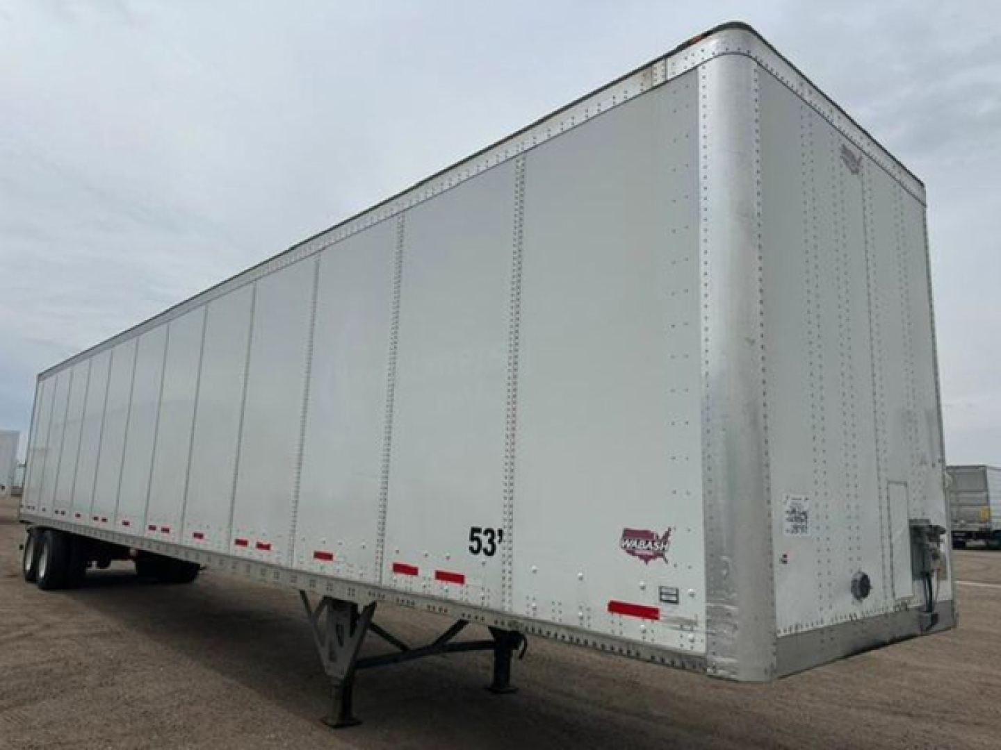 Trailer side view of a 53' Wabash van trailer with riveted aluminum walls and landing gear, stock number U90908, VIN 1JJV532D6GL908638.