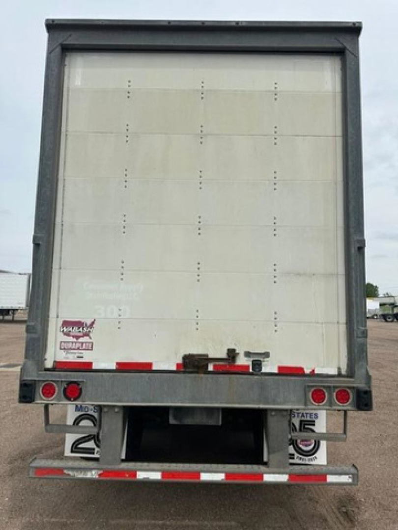 Rear view of a 2016 Wabash van trailer showing closed cargo door, bumper, and taillights with reflective tape.