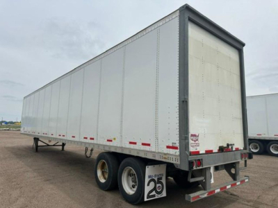 Trailer side view showing a 2016 Wabash box trailer with double rear doors, silver riveted panels, tandem axles, and red/white reflective tape.