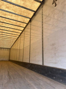 Interior of a Wabash van trailer showing empty cargo space with wood floor and white side walls.