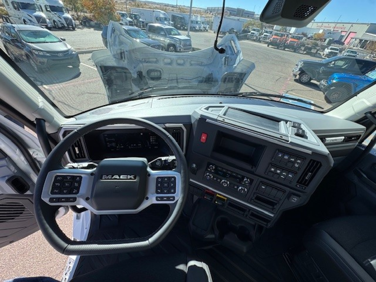 Mack PR64T cab interior showing steering wheel and dashboard controls.