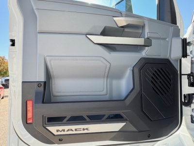Mack PR64T cab interior door panel view with speaker grille and 'MACK' branding on lower panel.