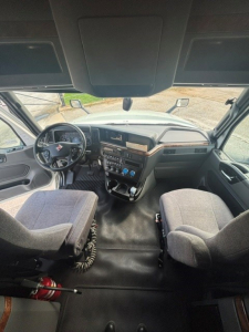 Cab interior of a 2021 International LT625 truck showing steering wheel, dashboard, and two front seats.