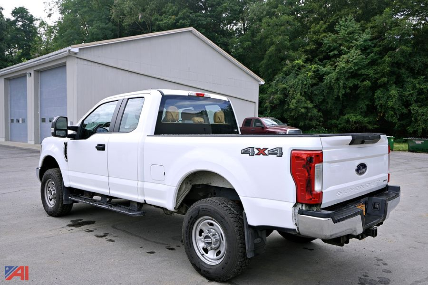 Ford F-350 Super Duty pickup truck with 4x4 badging showing rear and passenger side, white exterior, dual rear wheels, in a lot.