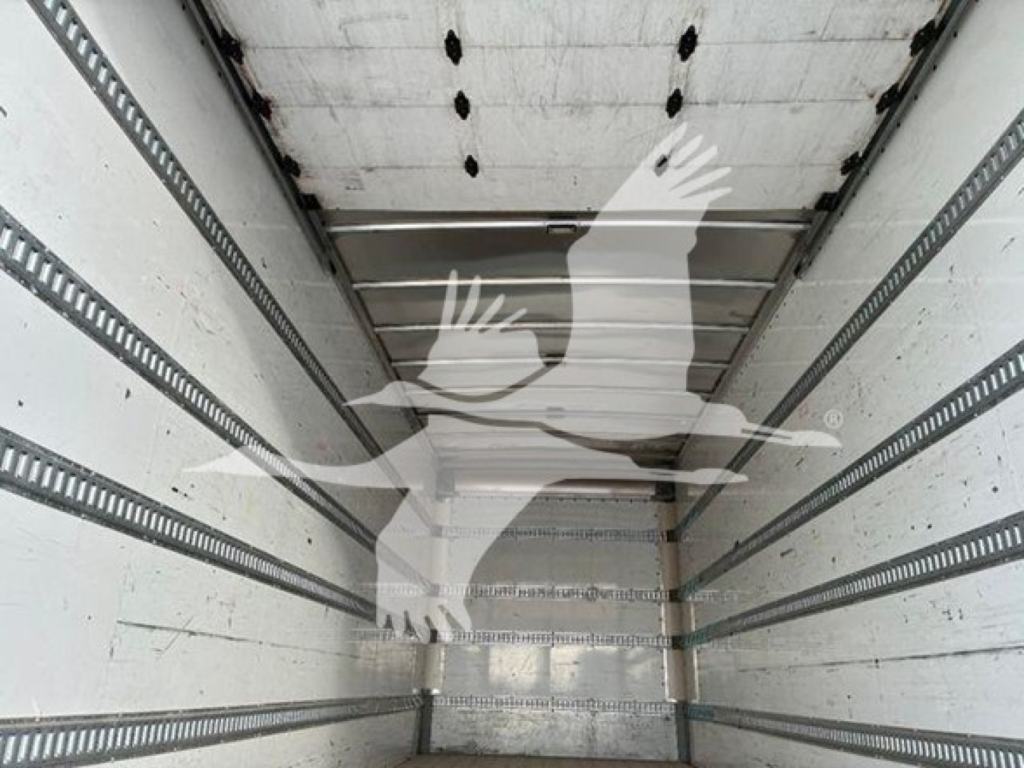 Trailer interior showing empty box with ribbed steel side rails and rear doors, cargo space visible.