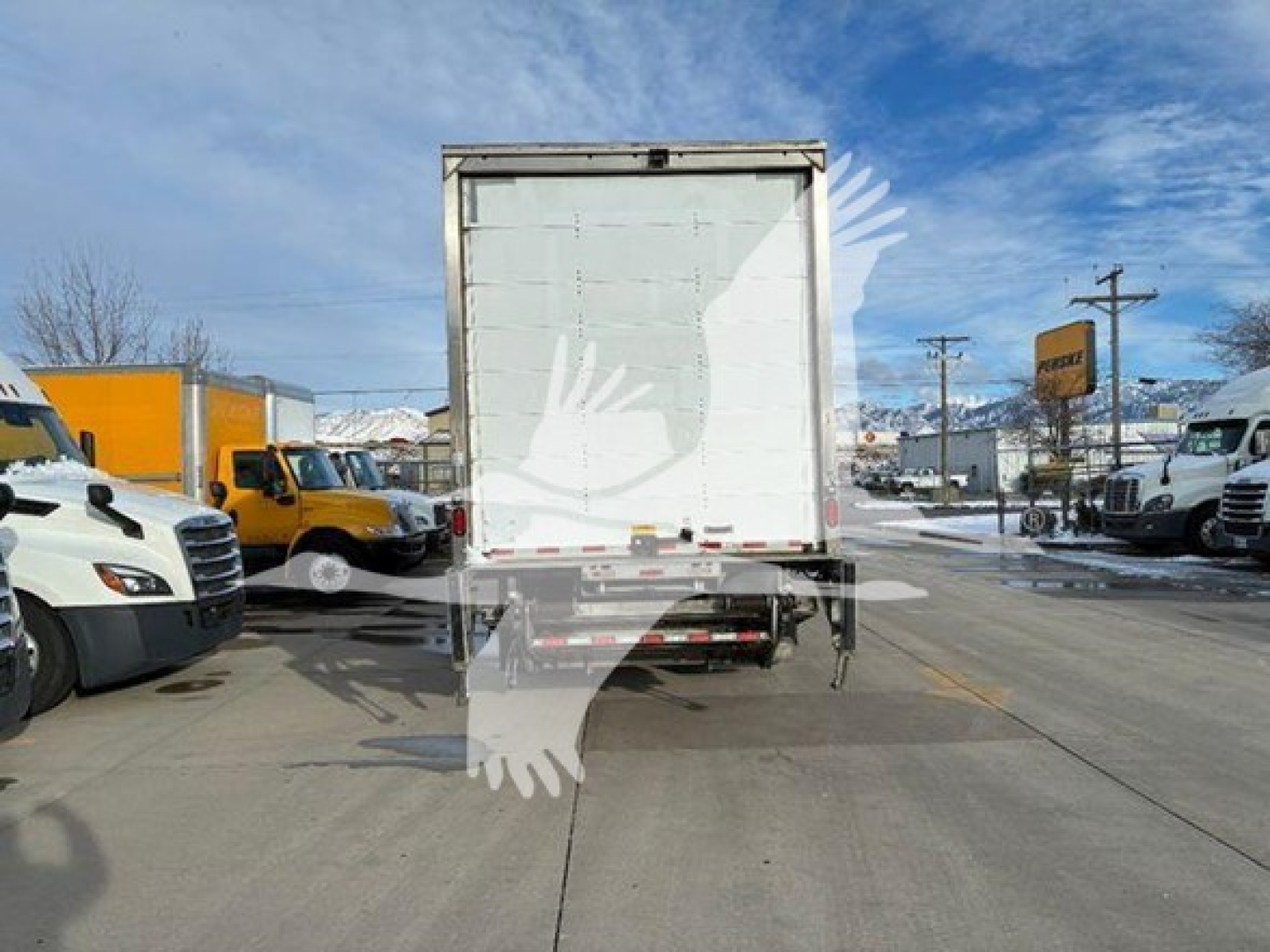 Box truck rear view showing cargo area and taillights with clear sky.