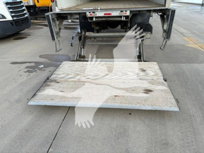 Box truck rear showing lowered aluminum ramp with hydraulic lift and taillift, International MV, stock number T64863 visible, VIN 3HAEUMML9ML864863.