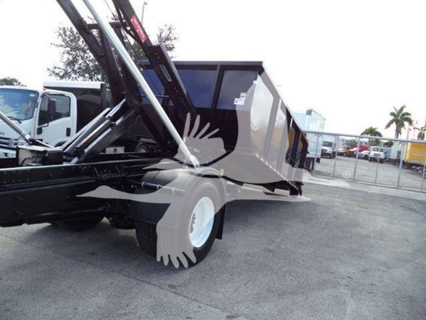 New/used 2019 International Durastar 4300 roll-off truck with open bed and hydraulic hoist, side view showing chassis and rear wheel