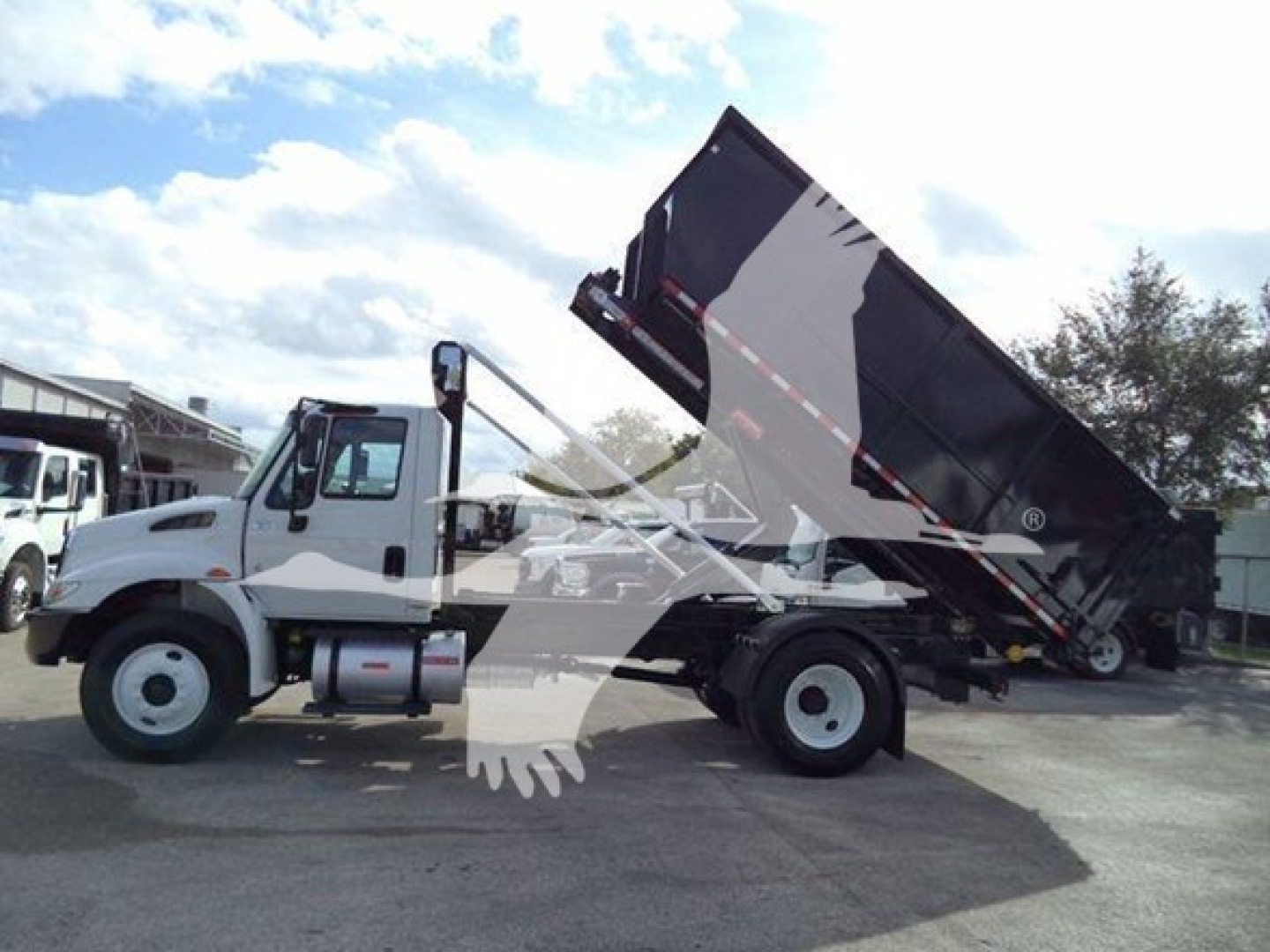 Dump truck with dump bed raised showing International Durastar 4300, cab in white and black cargo bed; VIN and stock hidden