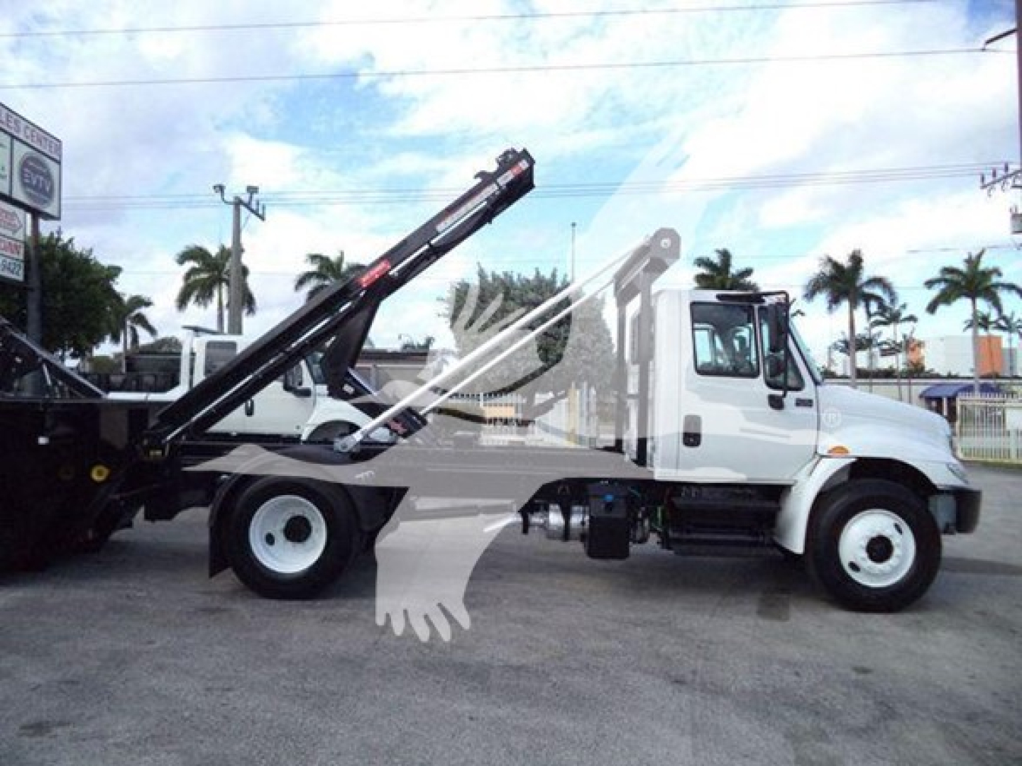 2019 International Durastar 4300 roll-off truck side view showing crane arm and hydraulic lift system.