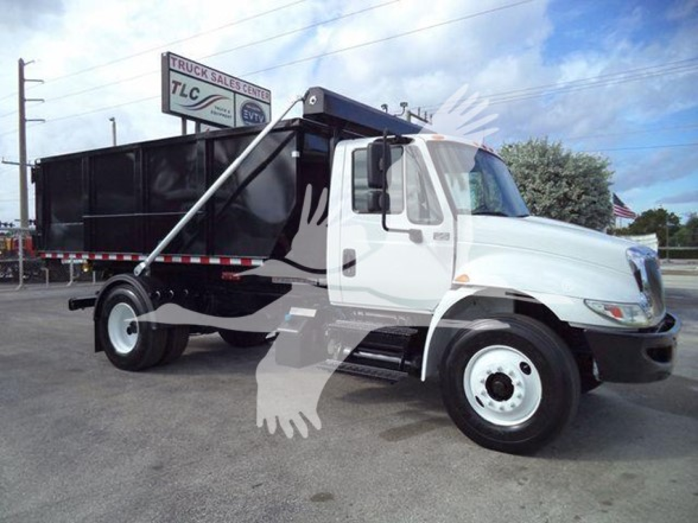 Truck profile showing a white 2019 International Durastar 4300 roll-off truck with black dump container and side panels.