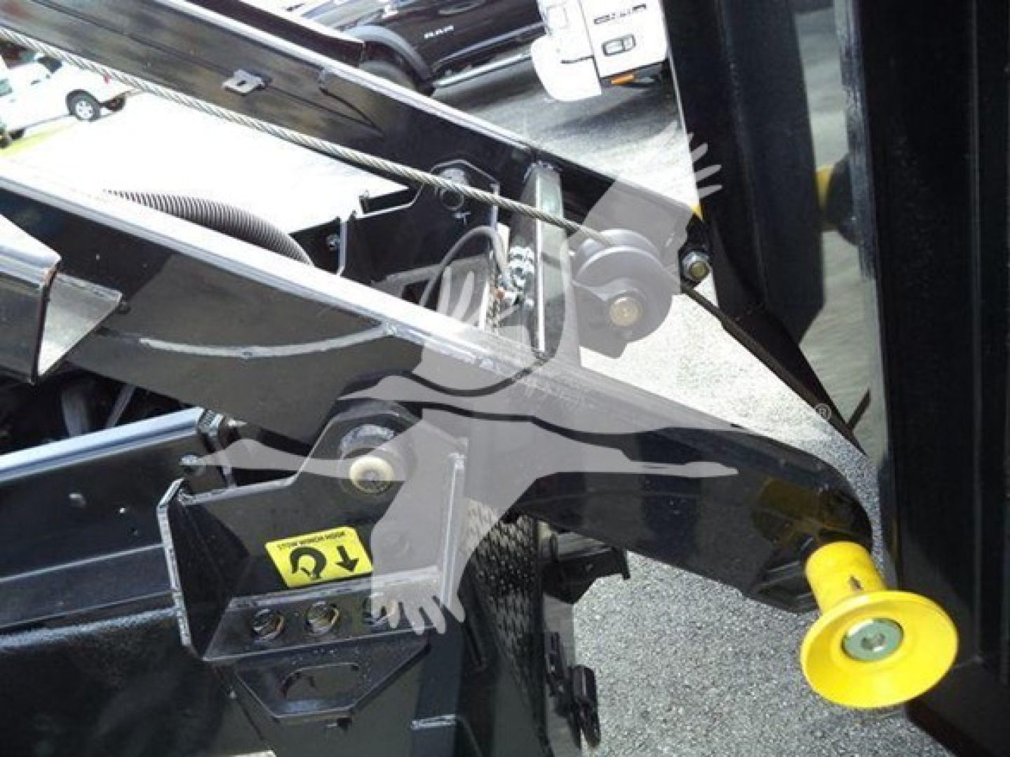 Truck chassis close-up showing lifting arm and yellow jack pad on International Durastar 4300 componentry.