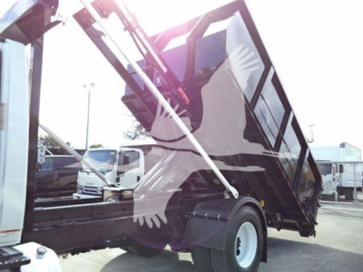 Dump truck in-service showing hydraulic dump bed raised, International Durastar 4300 style, side view with front cab and rear tipping mechanism.